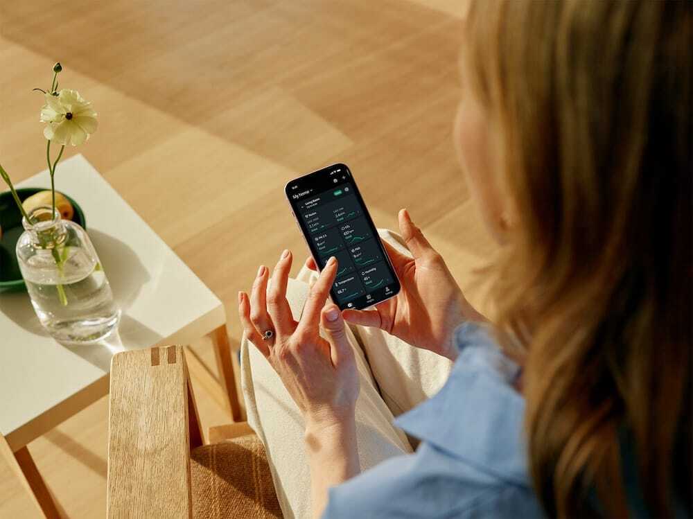 Person checking Airthings app with View Plus radon and air quality data