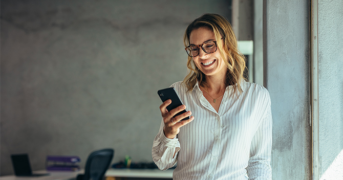 Woman smiling while looking at her phone