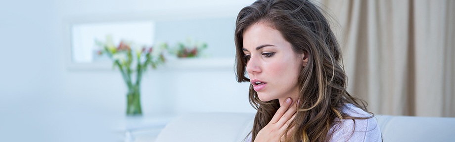 Woman with a hand to her throat indicating illness