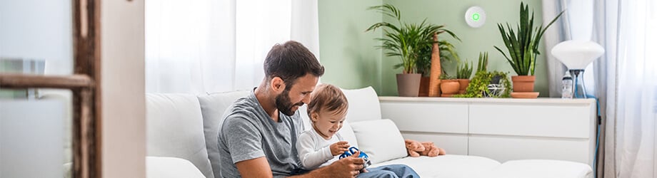 Father with young baby playing in living room