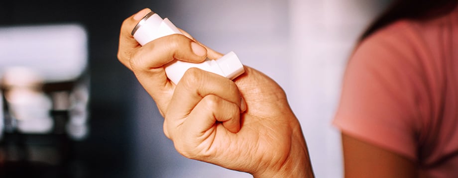 Asthma inhaler in a woman's hand