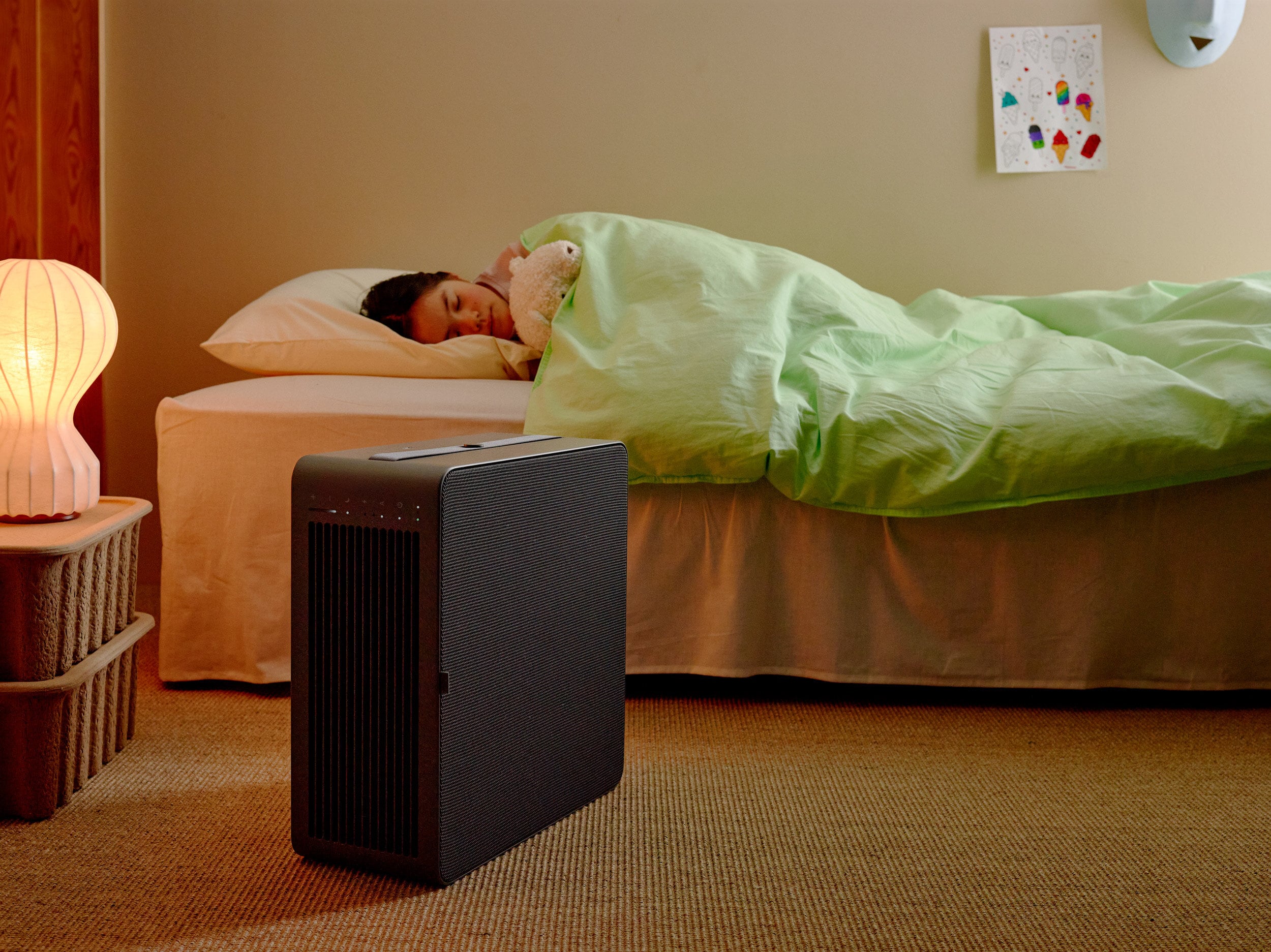 Airthings Renew HEPA-13 air purifier placed beside a bed for overnight wildfire smoke and allergen filtration